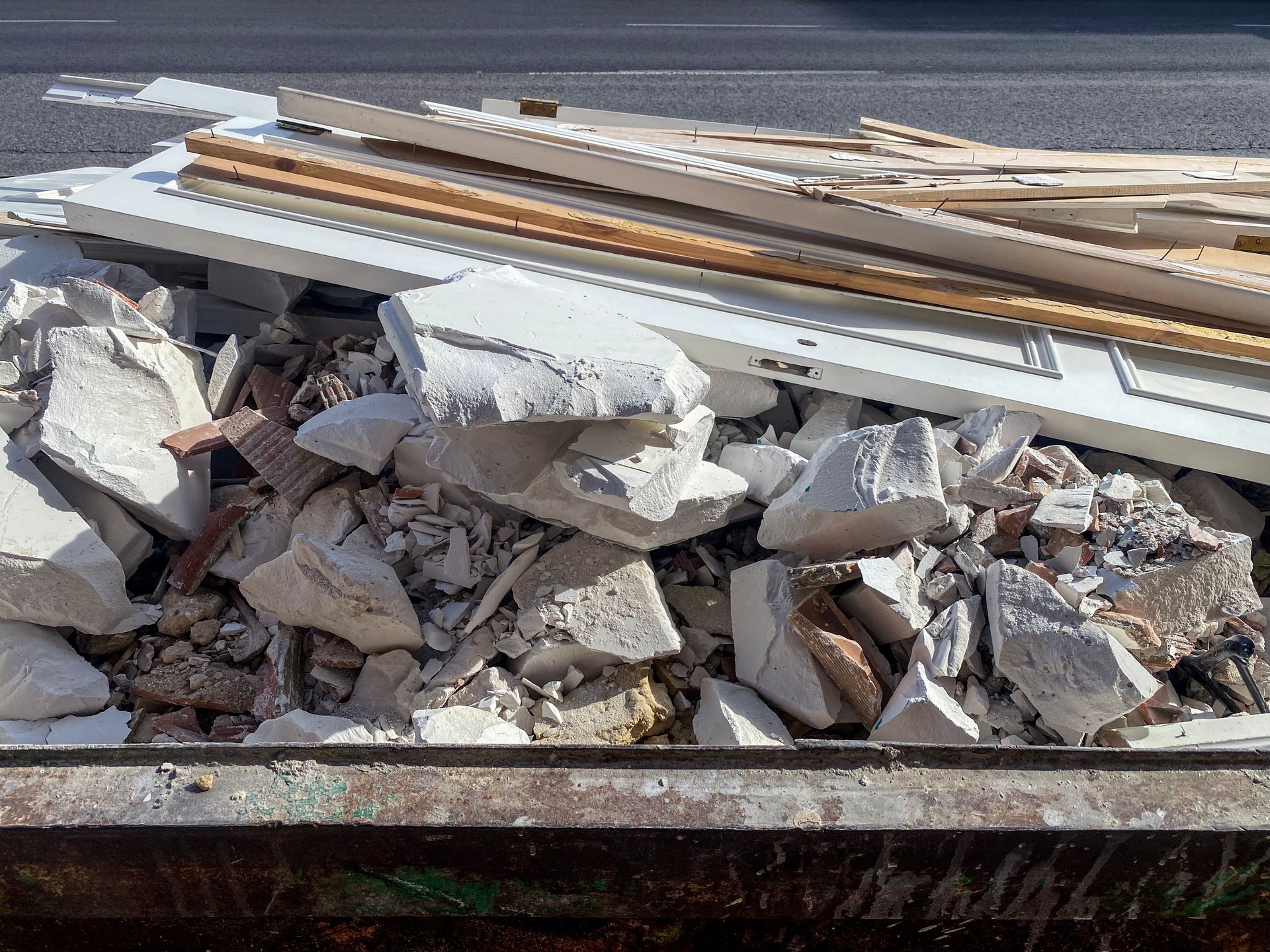 Rubble and wooden door in garbage container
